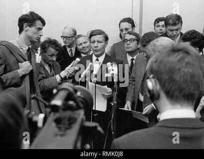 Chairman of the SPD-Bundestagfraktion (faction of a parliamentary party in the German Bundestag), Helmut Schmidt (center), gives a statement on the new cabinet list of the SPD to the press after the formation of government by Chancellor Willy Brandt.