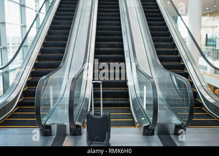 Three escalators side by side and suitcase in the office Stock Photo