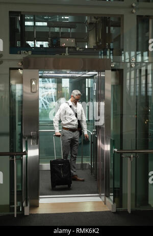 Businessman with travel suitcase in the elevator Stock Photo