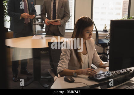 Woman working on computer at desk Stock Photo