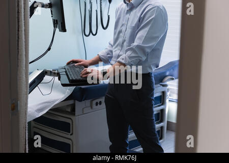 Young asian male doctor working on computer in clinic Stock Photo