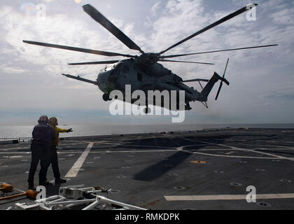 190212-N-BN355-0018 PACIFIC OCEAN (Feb. 12, 2019) Sailors signal the landing of a CH-53E Super Stallion assigned to Marine Medium Tiltrotor Squadron (VMM) 163 (REIN) during flight operations aboard the San Antonio-class amphibious transport dock ship USS John P. Murtha (LPD 26). John P. Murtha is underway conducting routine operations as part of USS Boxer Amphibious Ready Group (ARG) in the eastern Pacific Ocean. (U.S. Navy photo by Mass Communication Specialist 3rd Class Jailene Casso) Stock Photo