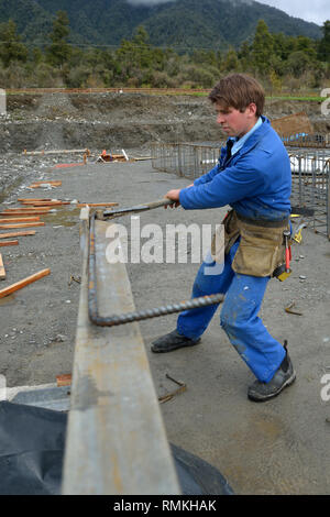 A builder bends reinforcing steel for foundations work on a large construction project Stock Photo