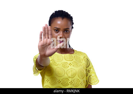 Young African American woman showing stop gesture while standing against white background Stock Photo