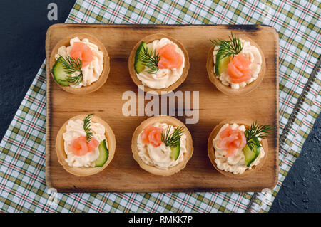 Tartlets with cream cheese and salted salmon. Tasty light snack for a party. Finger Food. The top view Stock Photo