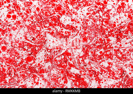 Abstract background of vivid red and white liquid paint mix with dense stains. Full frame backdrop concept with artistic marble texture Stock Photo
