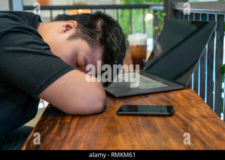 Asian freelancer sleeping in the cafe Stock Photo