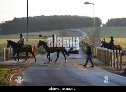 Horses and their riders exercise along the Warren Hill gallops in Newmarket Suffolk. Horse racing in Britain will resume tomorrow following a six day  Stock Photo