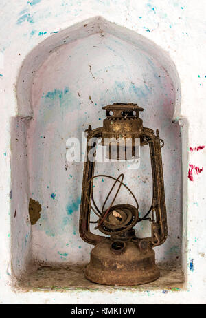 Beautiful photo of an obsolete and antique kerosene oil lantern kept in a wall shelf, once widely used as a source of light in rural India and Asia. Stock Photo