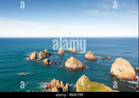 The Nuggets, ancient landforms on the Catlins Coast, New Zealand. Circle of rocky islets in a deep blue ocean Stock Photo