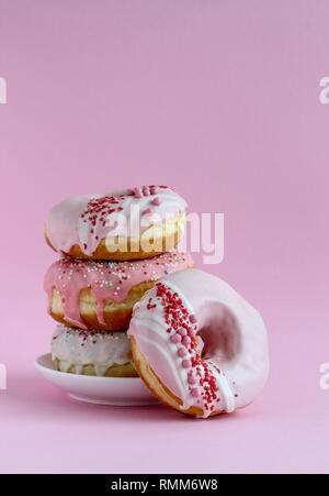 A stack of pink donuts on a pink background Stock Photo