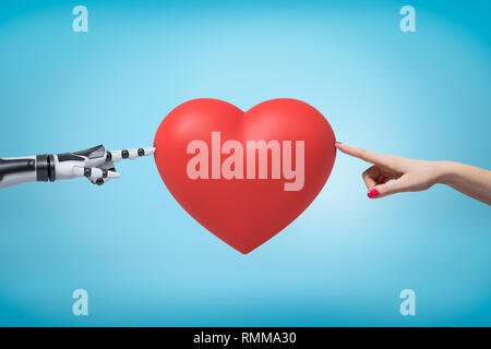 Woman's hand on the right and robot's hand on the left touching red Valentine heart with their fingertips. Stock Photo