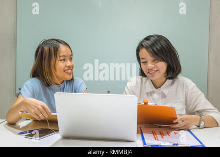 Smiling Asian businesswoman discuss about work in the office Stock Photo
