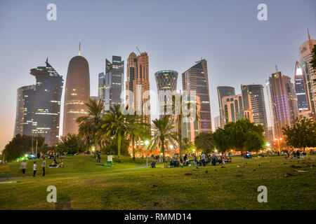 Doha, Qatar - November 4, 2016. Park along Corniche waterfront in Doha, with people and skyscrapers in the background. Stock Photo