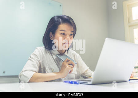 Young Asian woman thinking about the finance Stock Photo