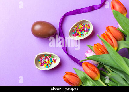Easter composition with chocolate eggs and tulips,  space for text , top view Stock Photo