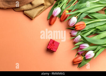 Fresh pink tulips on a table, top view. Tulips on the table and red gift with place for text Stock Photo