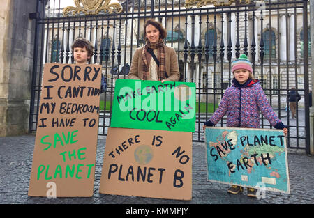 Rachel Agnew, from Broughshane, Co Antrim, with son Archie, aged 8, and daughter Bea, aged 5, both pupils at Broughshane Primary School at a climate change protest outside Belfast City Hall. Stock Photo