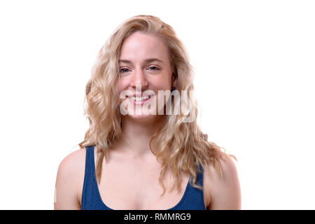 Front view studio shot portrait of a beautiful young woman with curly and healthy blond hair smiling while looking at camera against white background  Stock Photo