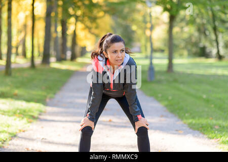 Adult smiling woman resting after running in park Stock Photo