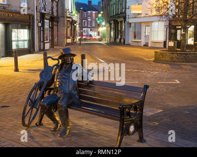Blind Jack seated statue by Barbara Asquith in the Market Place at dusk Knaresborough North Yorkshire England Stock Photo