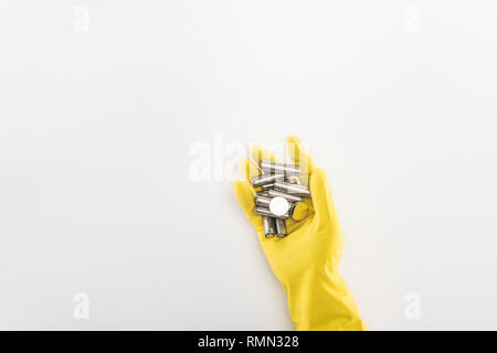 Cropped view of man in yellow rubber gloves holding batteries on grey background Stock Photo