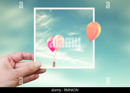 Hand holding an instant photo with air balloons, think outside the box concept Stock Photo