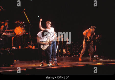 Musician Bryan Adams is shown performing 'live' in concert. Stock Photo