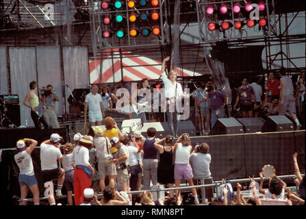 Musician Bryan Adams is shown performing 'live' in concert at Live Aid. Stock Photo