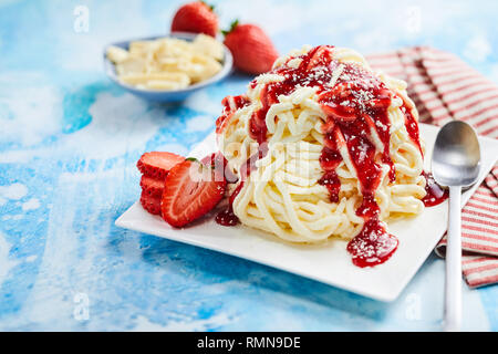 Spaghetti ice cream dessert with strawberry fruit topping in close up view Stock Photo