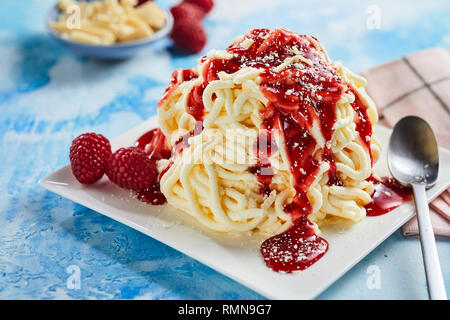 Portion of spaghetti ice cream dessert with sweet strawberry topping Stock Photo