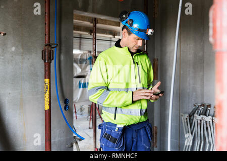 Builder using cell phone Stock Photo