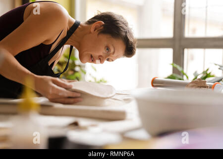 Young woman ceramic and pottery tableware at the workshop Stock Photo