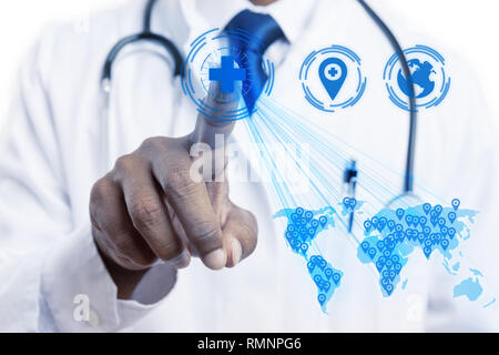 Male indian doctor touching with index finger medical cross symbol on invisible screen close-up as healthcare distribution on world map concept Stock Photo