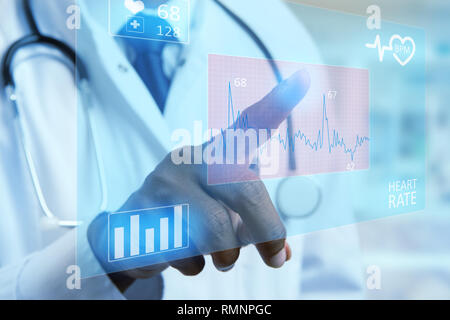 Close-up indian male cardiology medic touching heart rate graph on invisible display with index finger as futuristic medicine concept Stock Photo