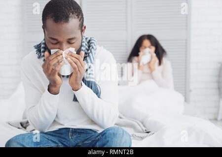Caught a cold. Silhouette of ill girl that lying in bed and covering her face Stock Photo
