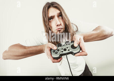 Lifestyle of young people. Student man spending time on playing games videogames console playstation. Long haired guy focus on gaming. Stock Photo