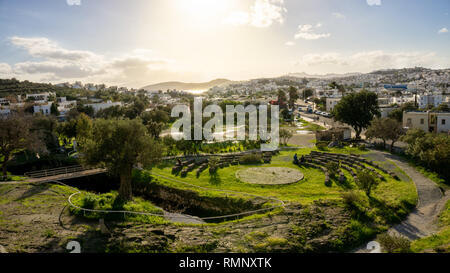 Myndos gate view of a bay of Bodrum, Mugla, Turkey. Beautiful sunset over the white houses and the archaeological ruins of the old city wall. Olive Stock Photo