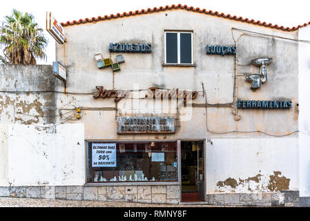 Cascais, Portugal - 6 December 2018: Hardware store front with multiple neon signs on facade advertising final days of closing-down sale in old town C Stock Photo