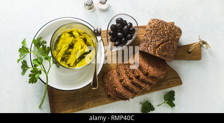 banner of sardines marinated in olive oil with rye bread, salt and pepper on the table. Italian Neapolitan homemade Mediterranean cuisine recipe. ligh Stock Photo