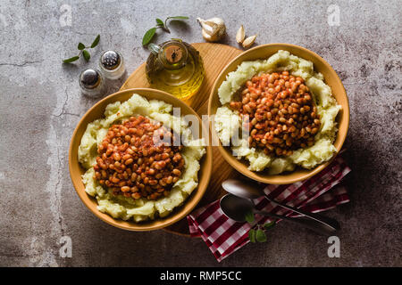 mashed potatoes with stewed white beans in tomatoes. winter warming recipe from vegan cuisine