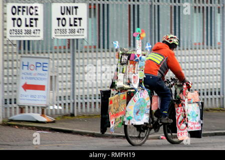 Glasgow, Scotland, UK 15th, February, 2019 Save the planet protester from the children's protest in George Square cycles home bedecked in kids protest art work maintaining integrity by not burning petrol.  Gerard Ferry/Alamy Live News Stock Photo