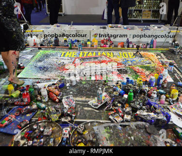 ExCeL London, Royal Docks, London, England, Friday 15th February 2019. The London Classic Car Show returns to the Thames side venue and is a an ideal opportunity to see cars from yesteryear.  Internationaly acclaimed artist Ian Cook depicts The Italian Job. Chris McEvoy/Alamy Live News. Stock Photo