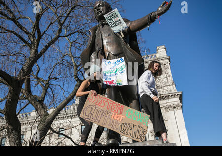 London, UK. 15th Feb, 2019. Two female students climb on the statues to display their banners. Thousands of primary school children, teenagers and university students have walked out of lessons today in more than 40 cities and towns of the UK to protest against climate change and urge the government to take action.The global movement has been inspired by teenage activist Greta Thunberg, who has been skipping school every Friday since August to protest outside the Swedish parliament. Credit: Angeles Rodenas/SOPA Images/ZUMA Wire/Alamy Live News Stock Photo