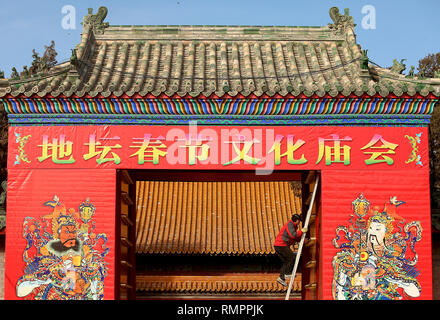 January 29, 2018 - Beijing, China - A Chinese worker puts the final touches on the hanging of large temple god murals on the front gate of a temple in Beijing on January 29, 2018.  China's capital is gearing up for the upcoming Chinese New Year and Spring Festival, which will be the Year of the Dog.. (Credit Image: © Todd Lee/ZUMA Wire/ZUMAPRESS.com) Stock Photo