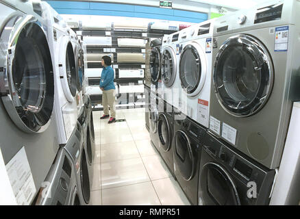 Beijing, China. 24th Jan, 2018. A Chinese saleswoman waits for customers next to washing machines at an appliance store in Beijing on January 24, 2018. China and South Korea have vowed to defend their interests after U.S. President Donald Trump slapped new tariffs on imported washing machines and solar panels to address a trade imbalance. Credit: Todd Lee/ZUMA Wire/ZUMAPRESS.com/Alamy Live News Stock Photo