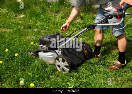Starting an lawn mower to mow lawns. Stock Photo