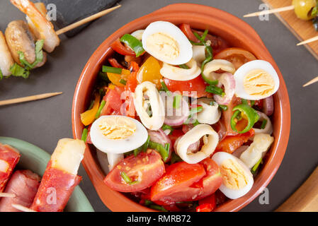 Top view of Spanish tapas snacks with olives, squid, anchovies and peppers Stock Photo