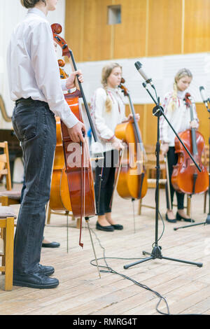 Children's violin ensemble. Children with violins on stage. Children's initiative, small talents. Early child development. vertical photo. Blurred. Stock Photo
