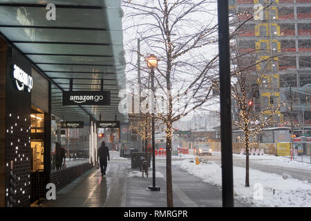 Amazon Go storefront signs in downtown Seattle during a winter snow storm, pedestrian on sidewalk. Stock Photo